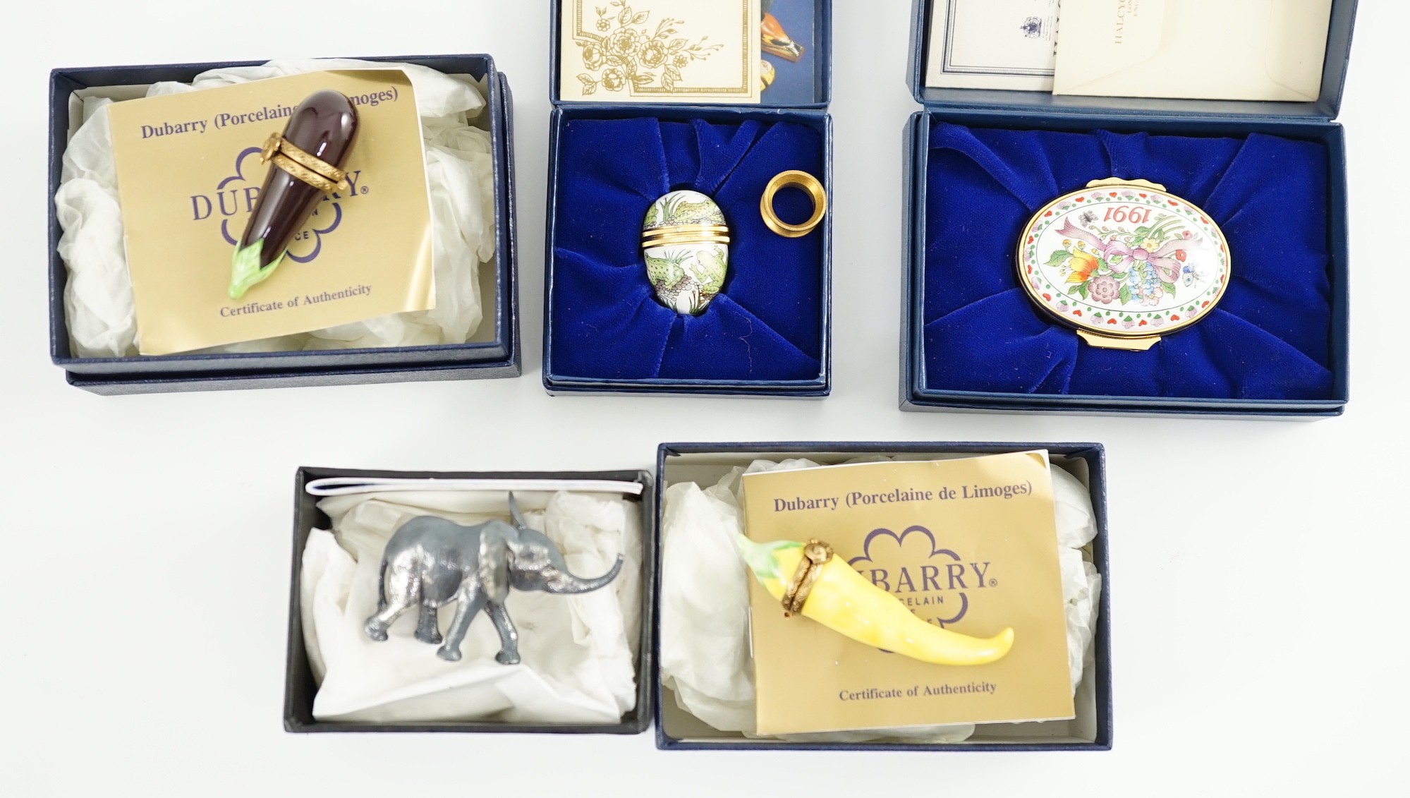 Two Halcyon Days enamel boxes; frog and 1991, two Dubarry boxes and a white metal model elephant, all boxed.